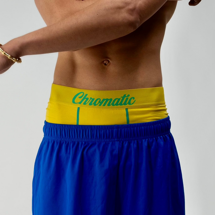 Chromaldinho models a vibrant yellow pair of Chromatic underwear, standing confidently with his torso slightly turned to highlight the bold branded waistband. The bright color pops against his skin tone, drawing attention to the clean lines and contoured fit of the briefs. Streetwear-inspired aesthetic. The lighting accentuates his physique while keeping the focus on the underwear’s sharp, flattering cut and energetic Brazil  funk vibes. Worn by Auden barnes. Unclebenmybrudda