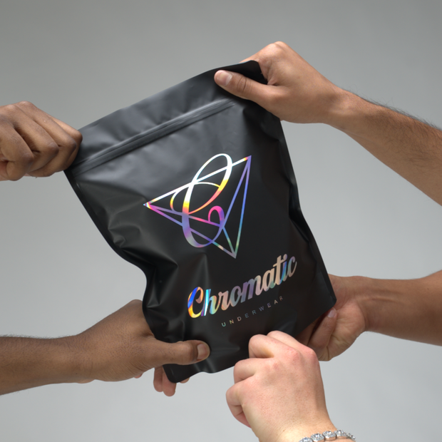 Chromatic packaging with a colourful logo and 'Chromatic' text held by four hands 