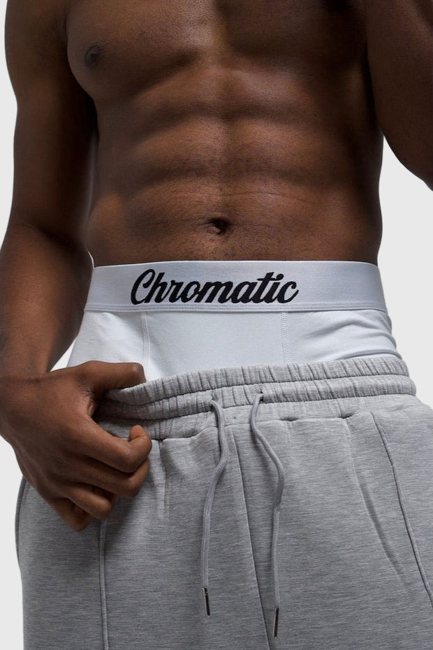 Person sagging grey shorts with a white and black pair of Chromatics white black logo on waistband