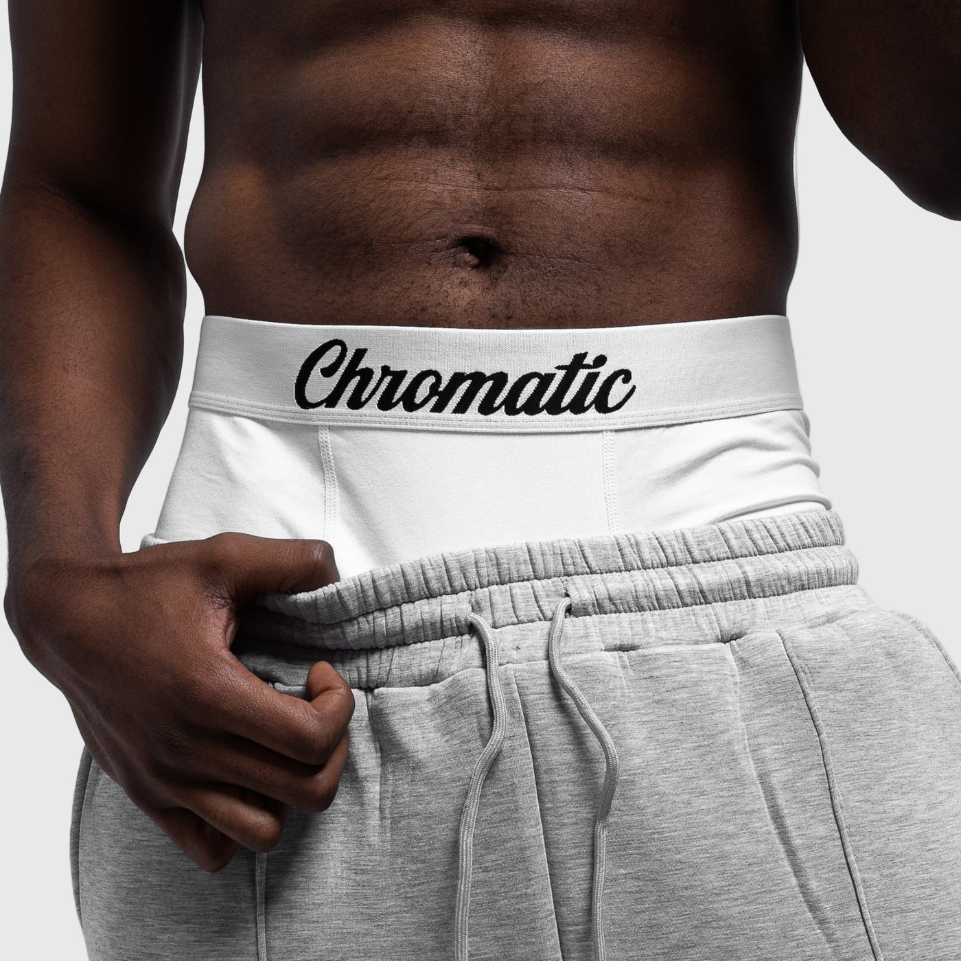 model wearing white underwear with 'Chromatic' branding and gray sweatpants.